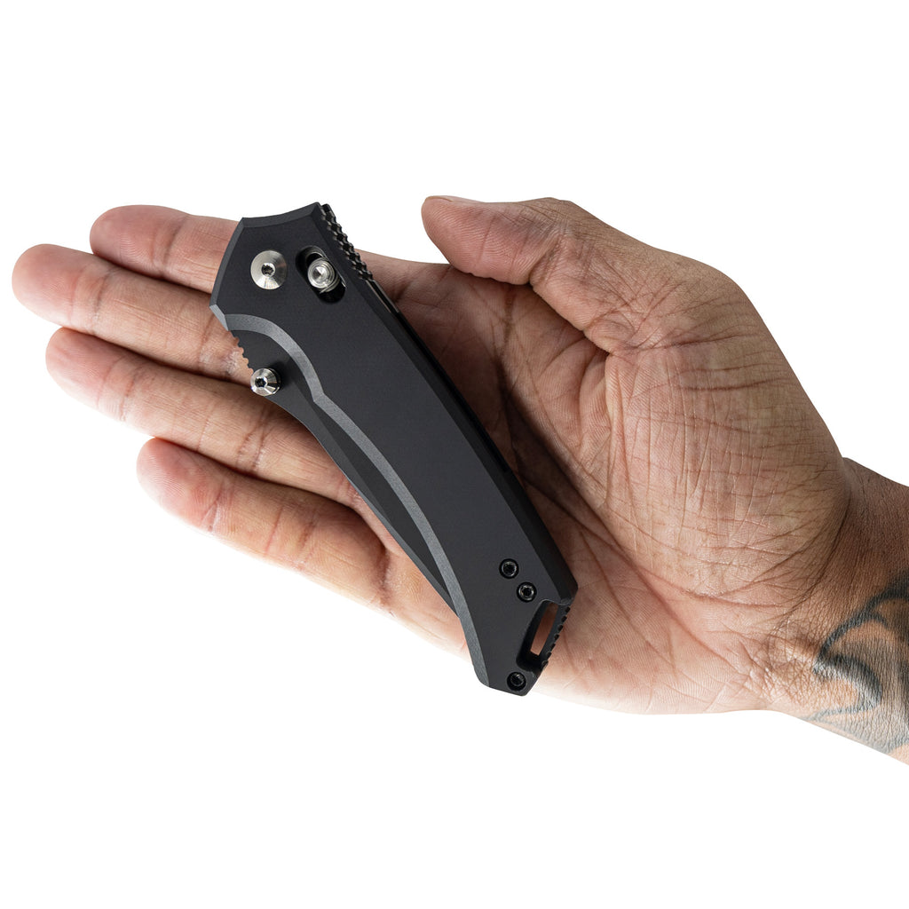 Hand holding a black folding knife on a white background