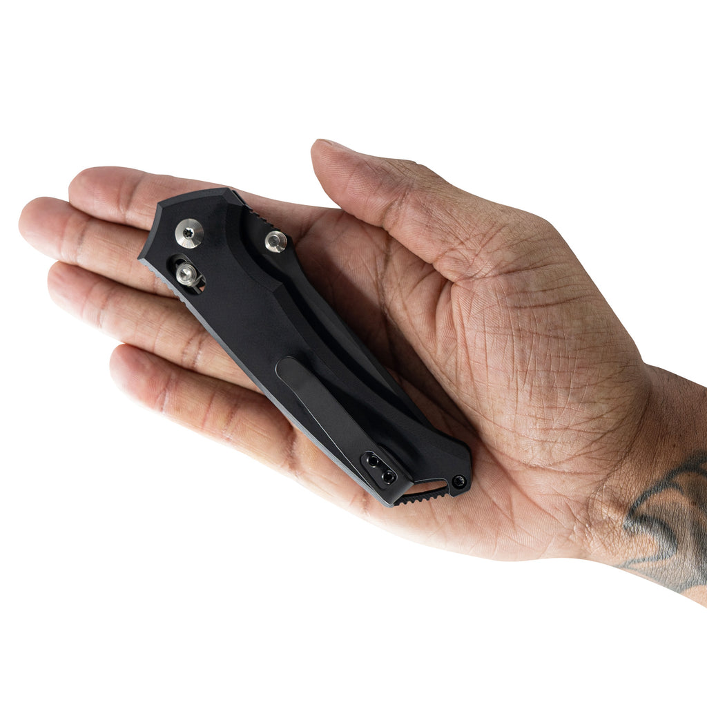 Hand holding a black multi-tool against a white background